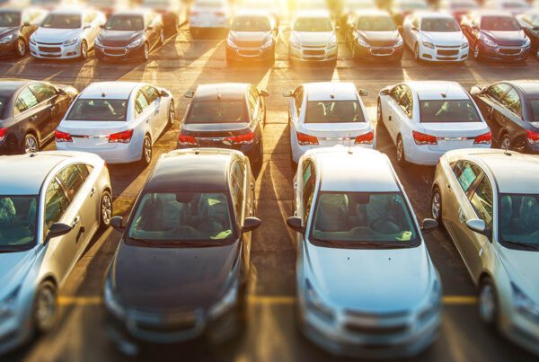 Business Auto Insurance - Fleet of Cars Sitting in the Parking Lot with the Sun Behind