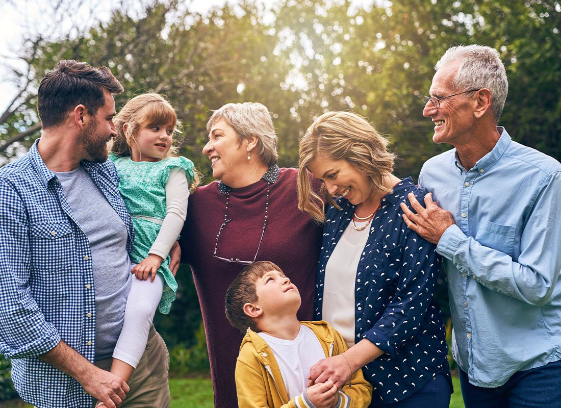 Employee Benefits - Happy Multigenerational Family Portrait Outdoors at Sunset