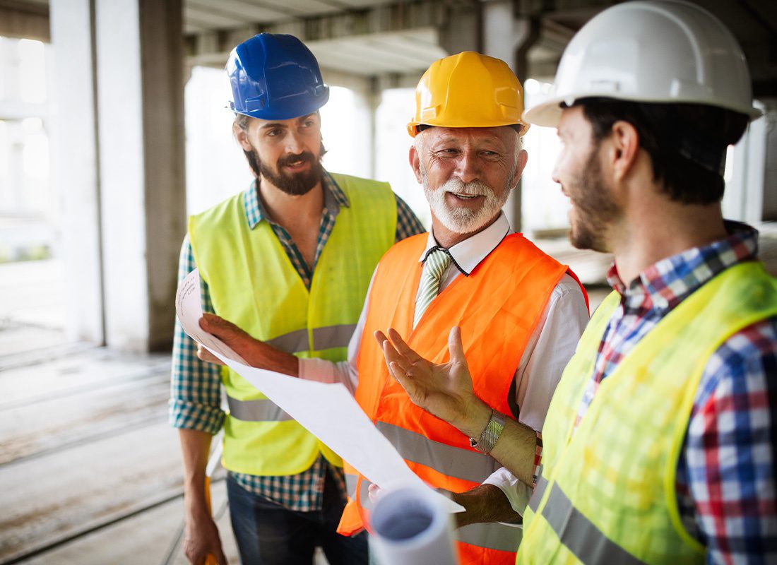 Insurance by Industry - Construction Engineers Discussing Plans With Architect at a Construction Building Site